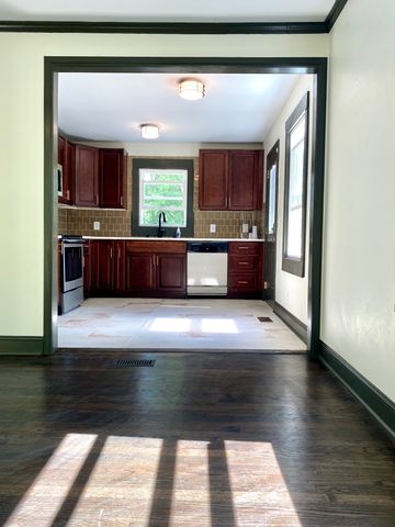 a living room with a bed and a dresser next to a window