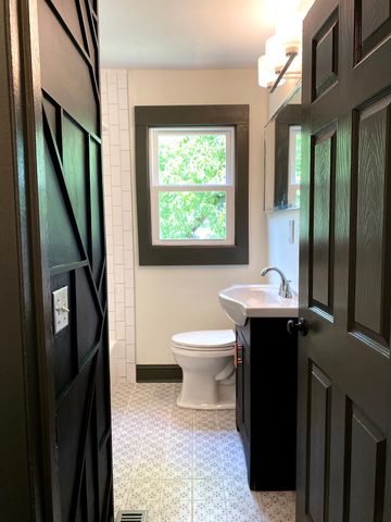 a bathroom with a toilet sink and mirror