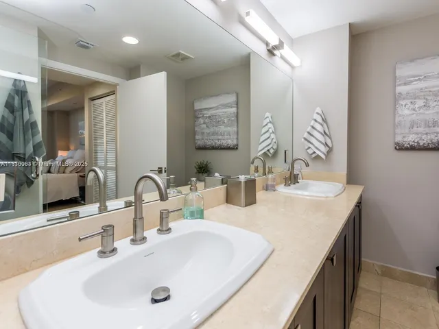 a bathroom with double sink and a mirror
