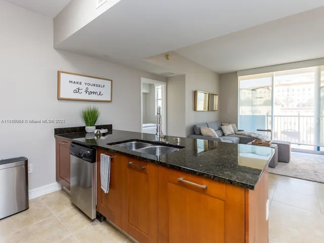 a kitchen with granite countertop a sink and a stove top oven