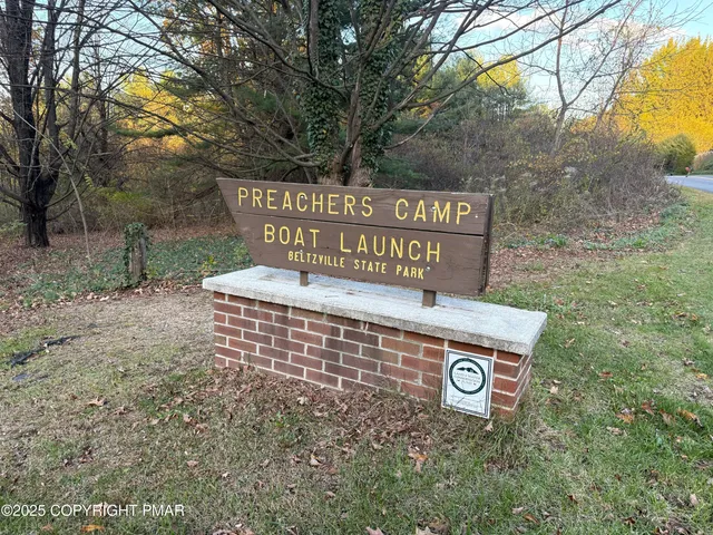 a view of a street sign under a large tree