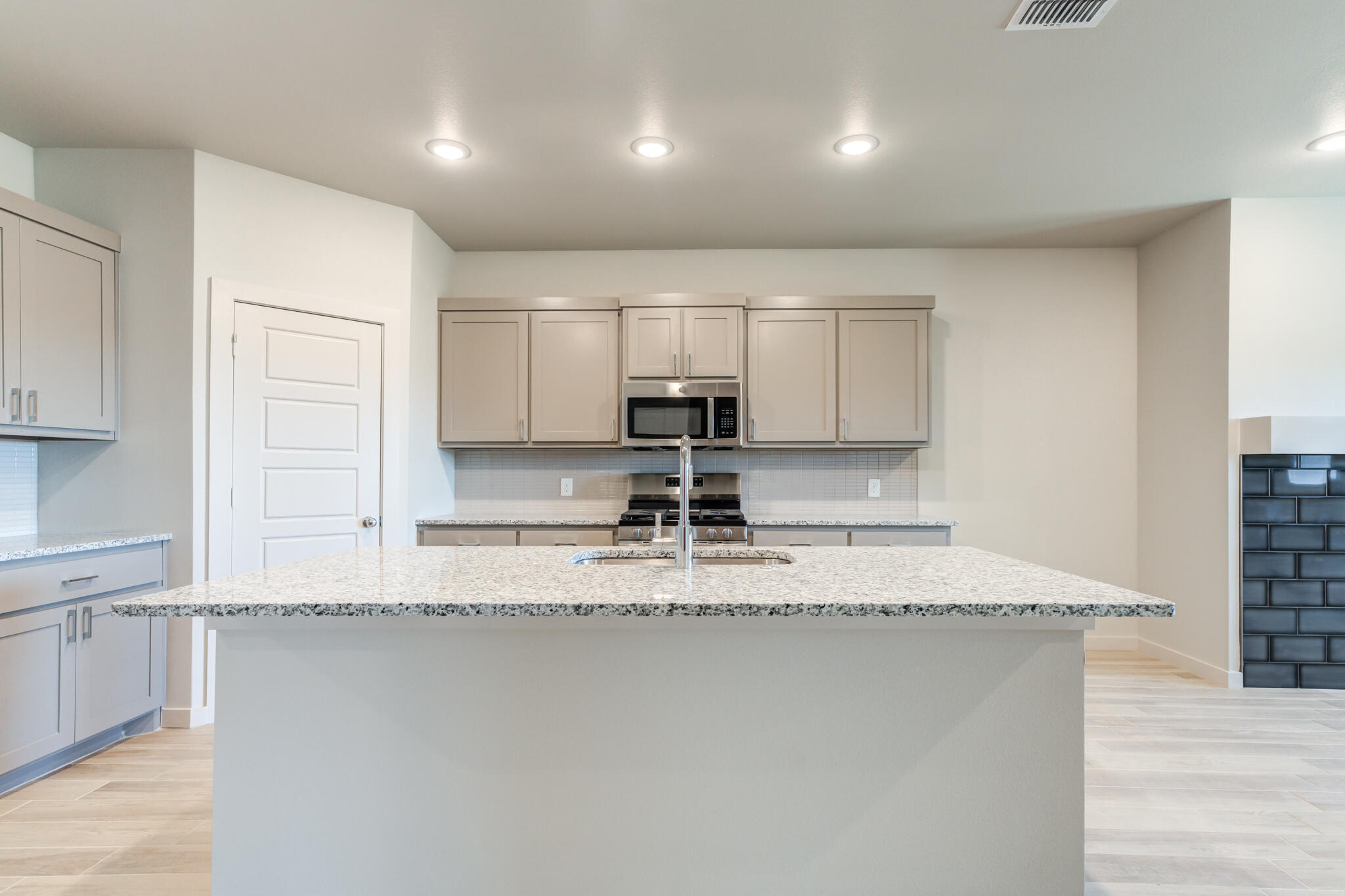 7029 25th Street Lubbock, TX 79407 - Photo 11 of 52 a kitchen with kitchen island granite countertop a sink window and cabinets