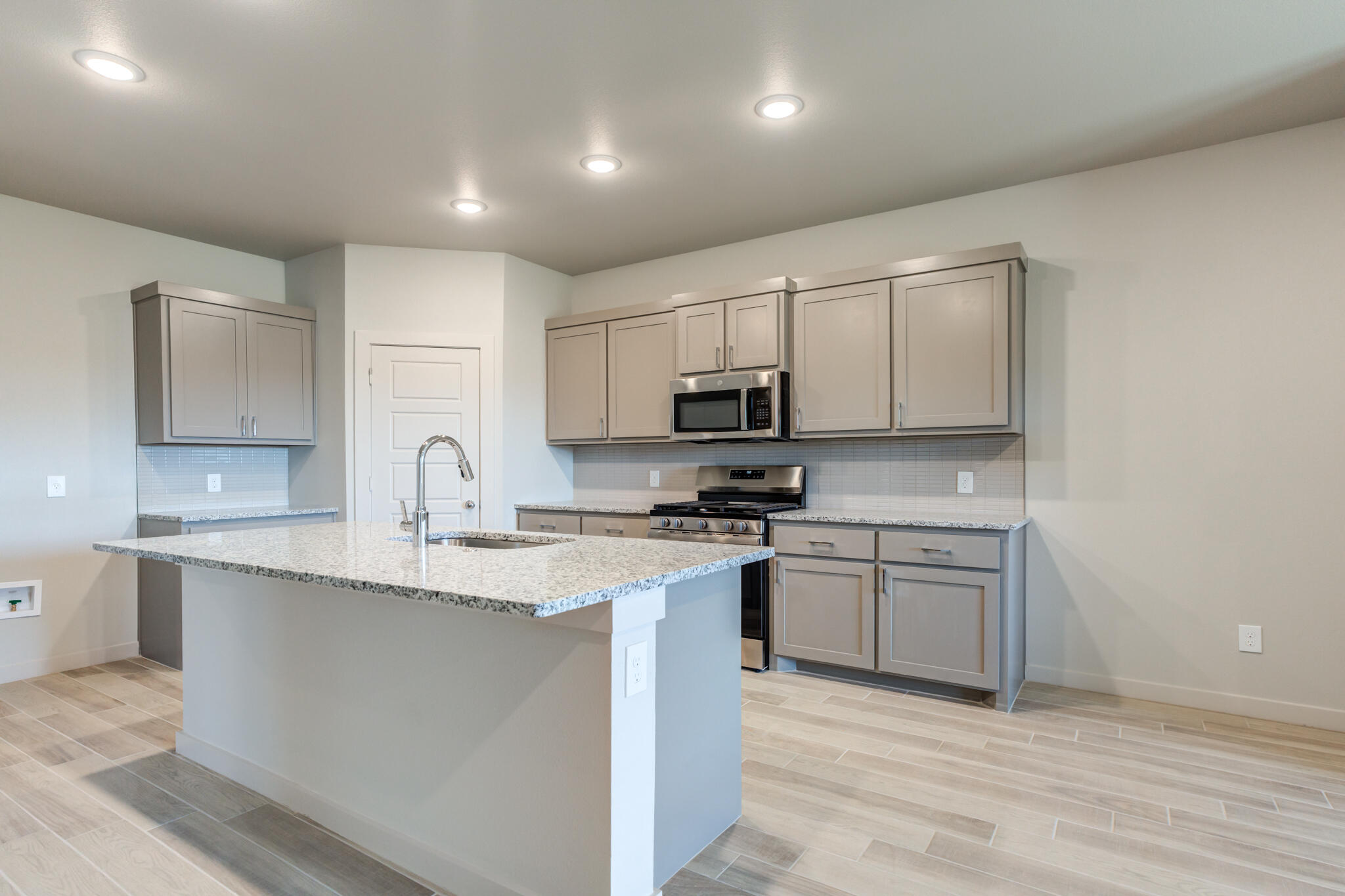 7029 25th Street Lubbock, TX 79407 - Photo 12 of 52 a kitchen with stainless steel appliances granite countertop a sink stove and microwave