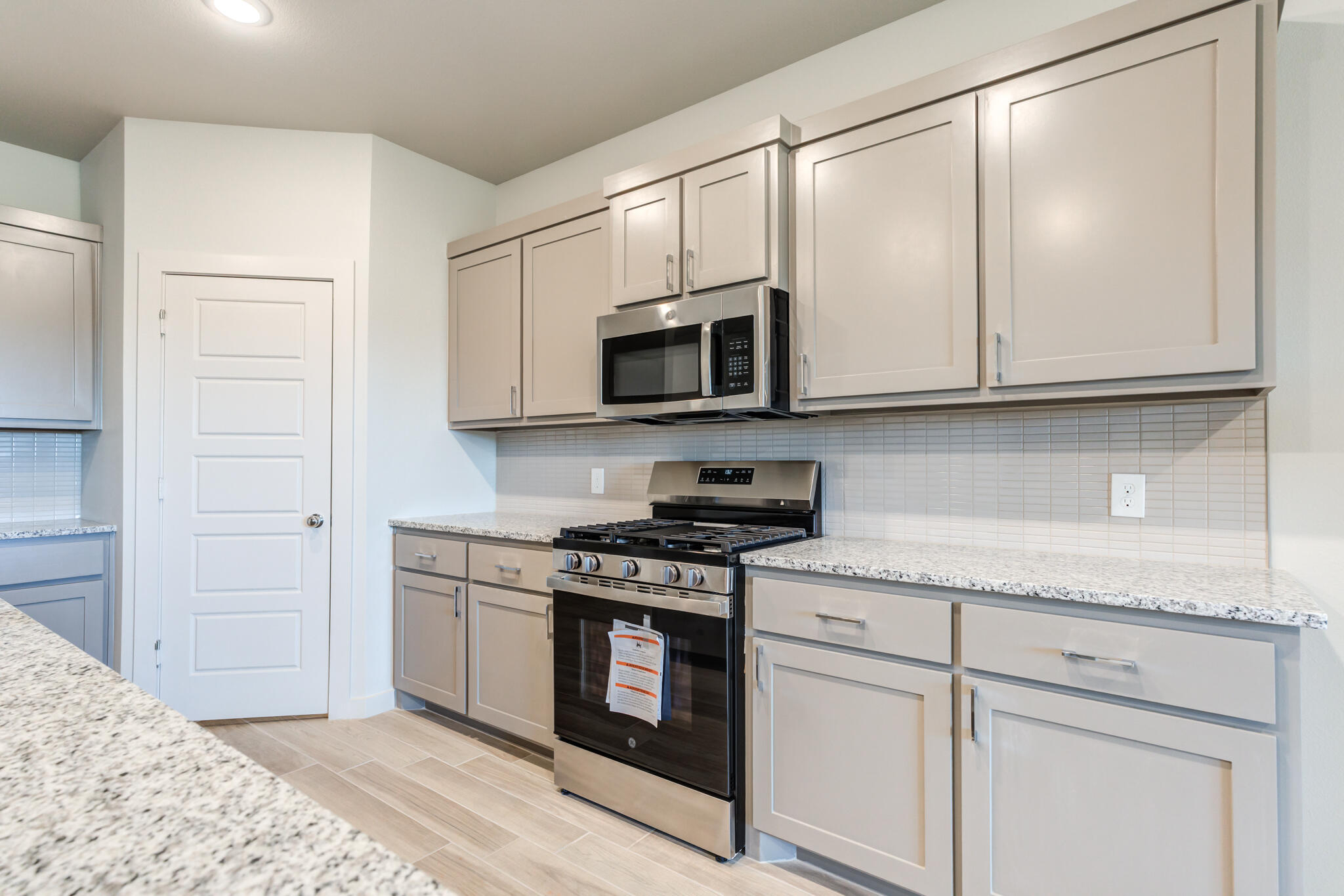 7029 25th Street Lubbock, TX 79407 - Photo 15 of 52 a kitchen with stainless steel appliances granite countertop white cabinets and a stove top oven