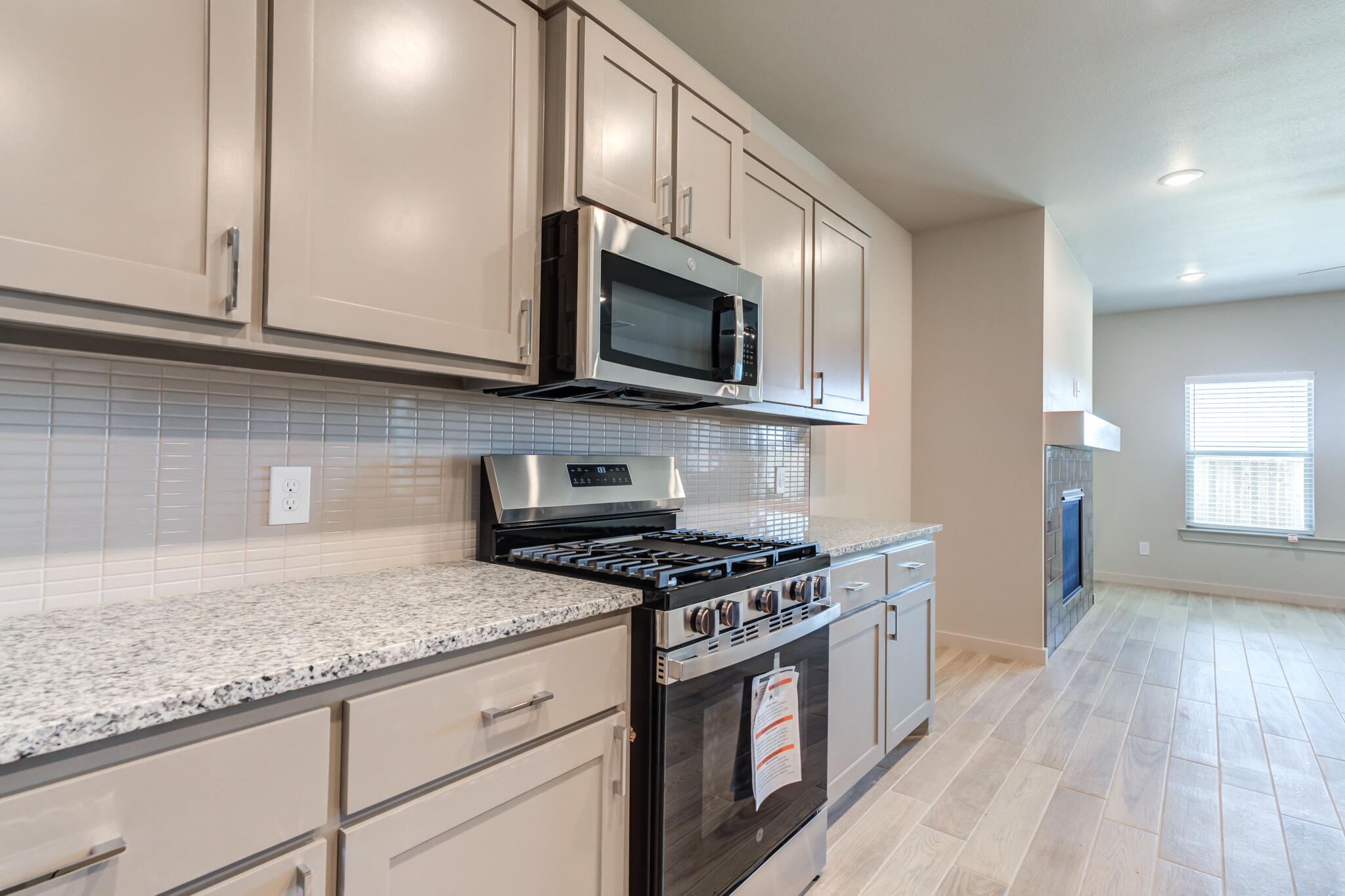 7029 25th Street Lubbock, TX 79407 - Photo 18 of 52 a kitchen with granite countertop a sink cabinets and stainless steel appliances