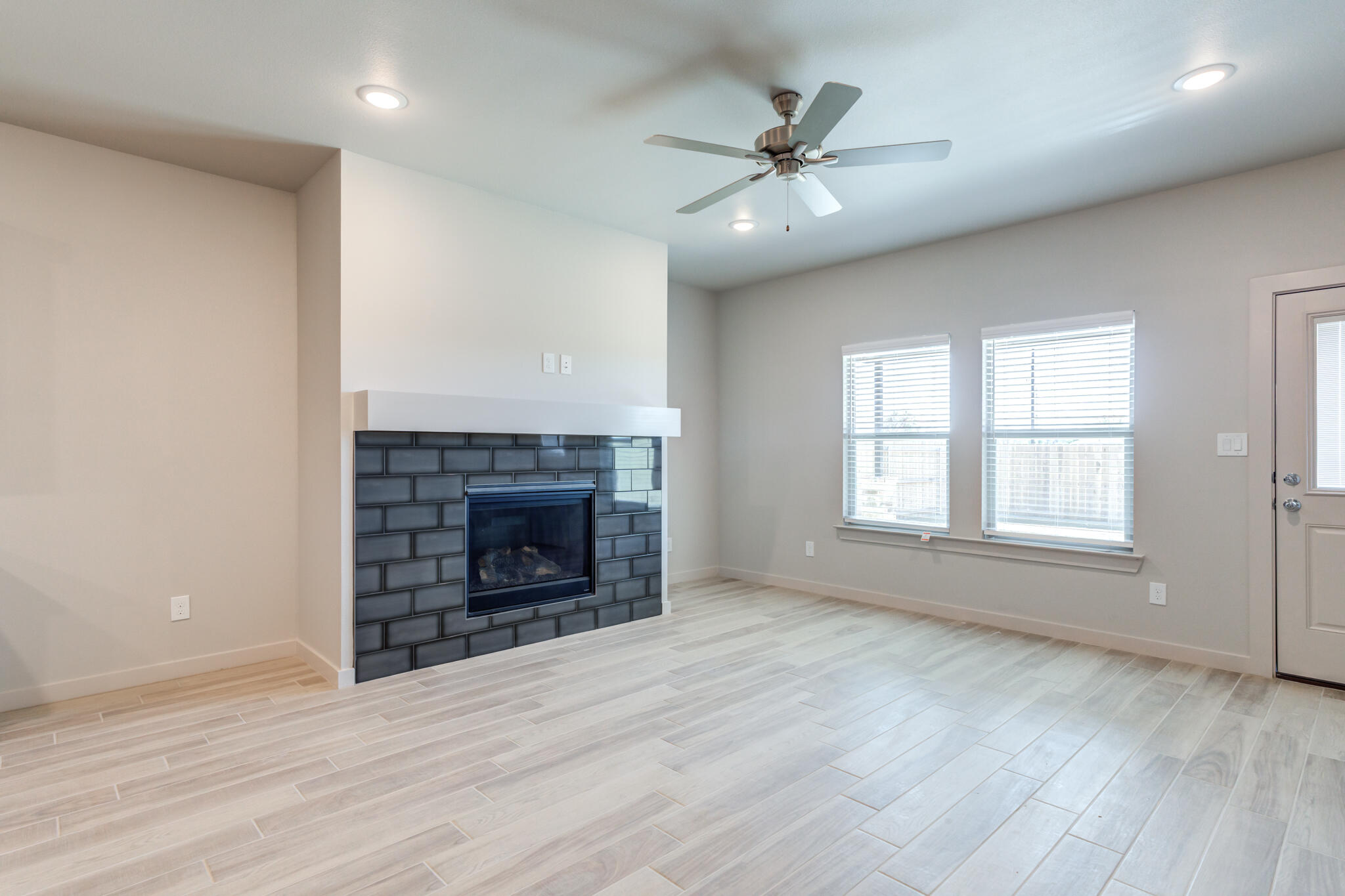 7029 25th Street Lubbock, TX 79407 - Photo 24 of 52 an empty room with windows and a fireplace