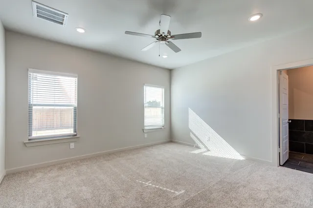 an empty room with fan and windows