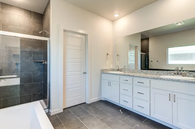 a bathroom with a granite countertop sink a mirror and a shower