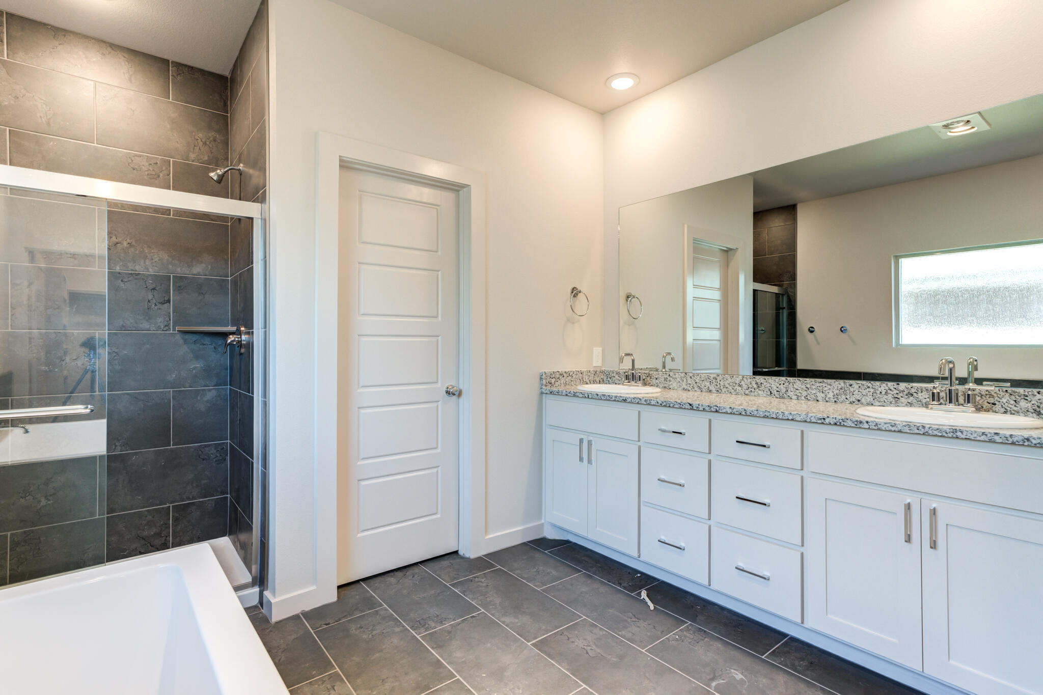 7029 25th Street Lubbock, TX 79407 - Photo 29 of 52 a bathroom with a granite countertop sink a mirror and a shower