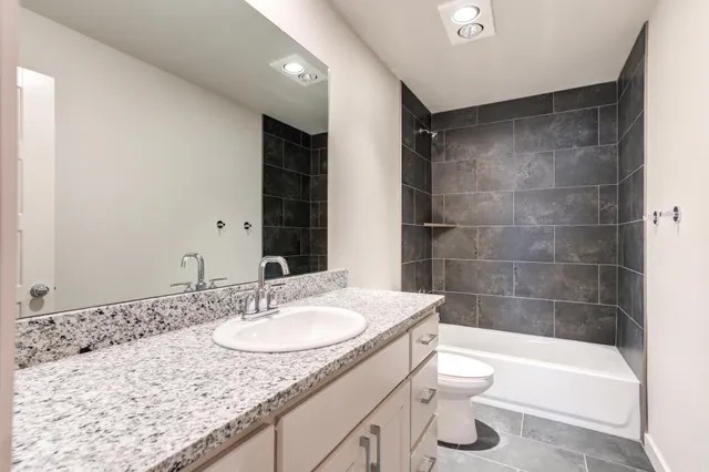 an empty room with a chandelier fan and windows