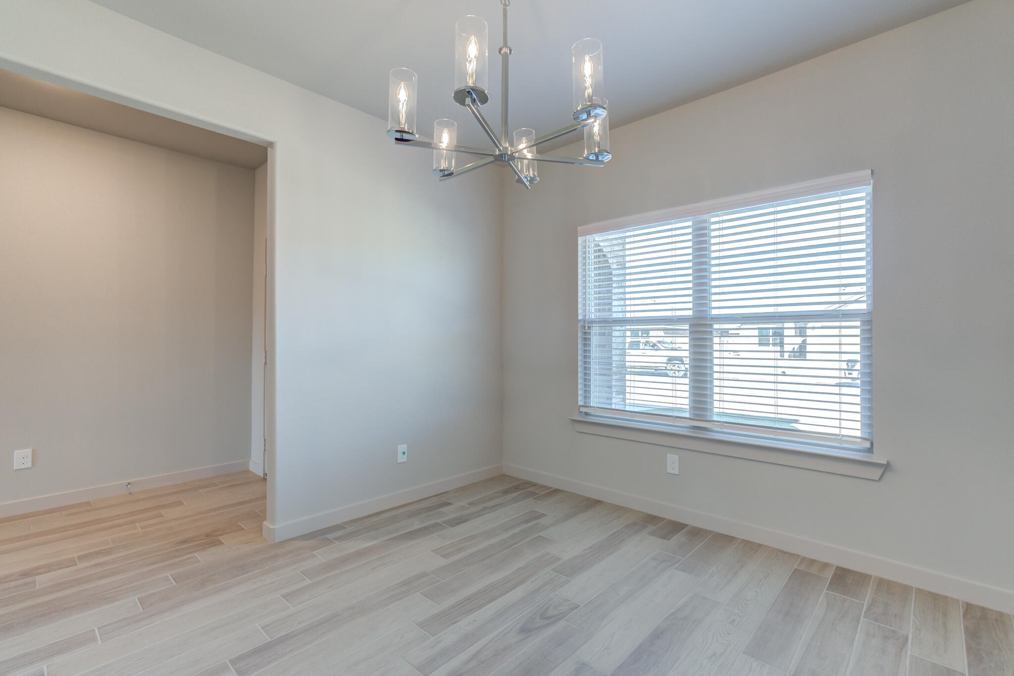 7029 25th Street Lubbock, TX 79407 - Photo 7 of 52 a view of an empty room with wooden floor and a window