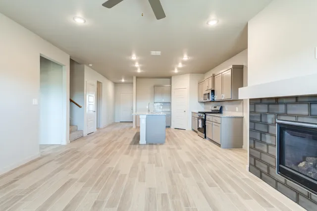 a open kitchen with kitchen island a sink stainless steel appliances and cabinets