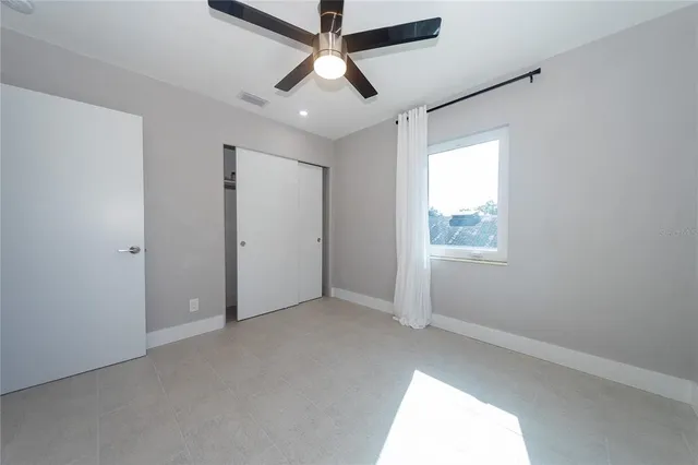 an empty room with chandelier fan