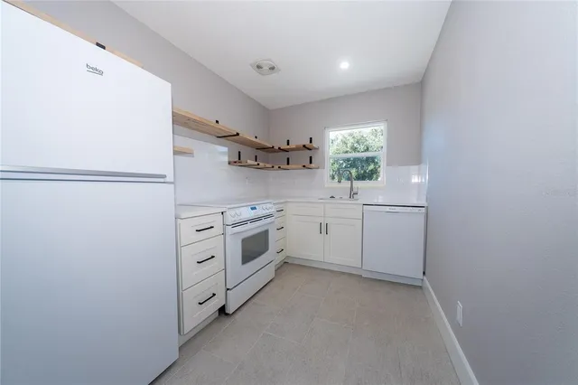 a kitchen with white cabinets and white appliances