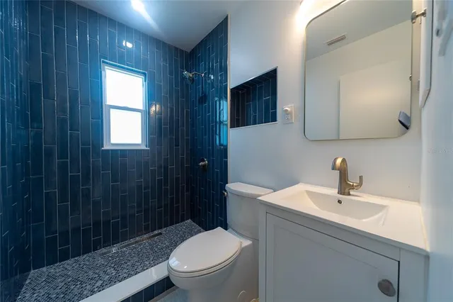 a bathroom with a sink a toilet and shower