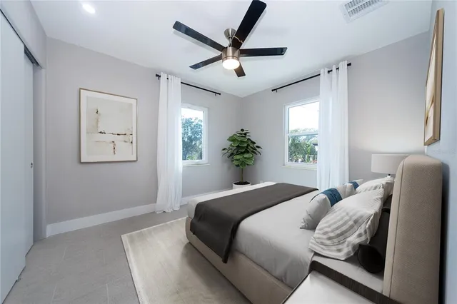 a bedroom with a bed and a large window