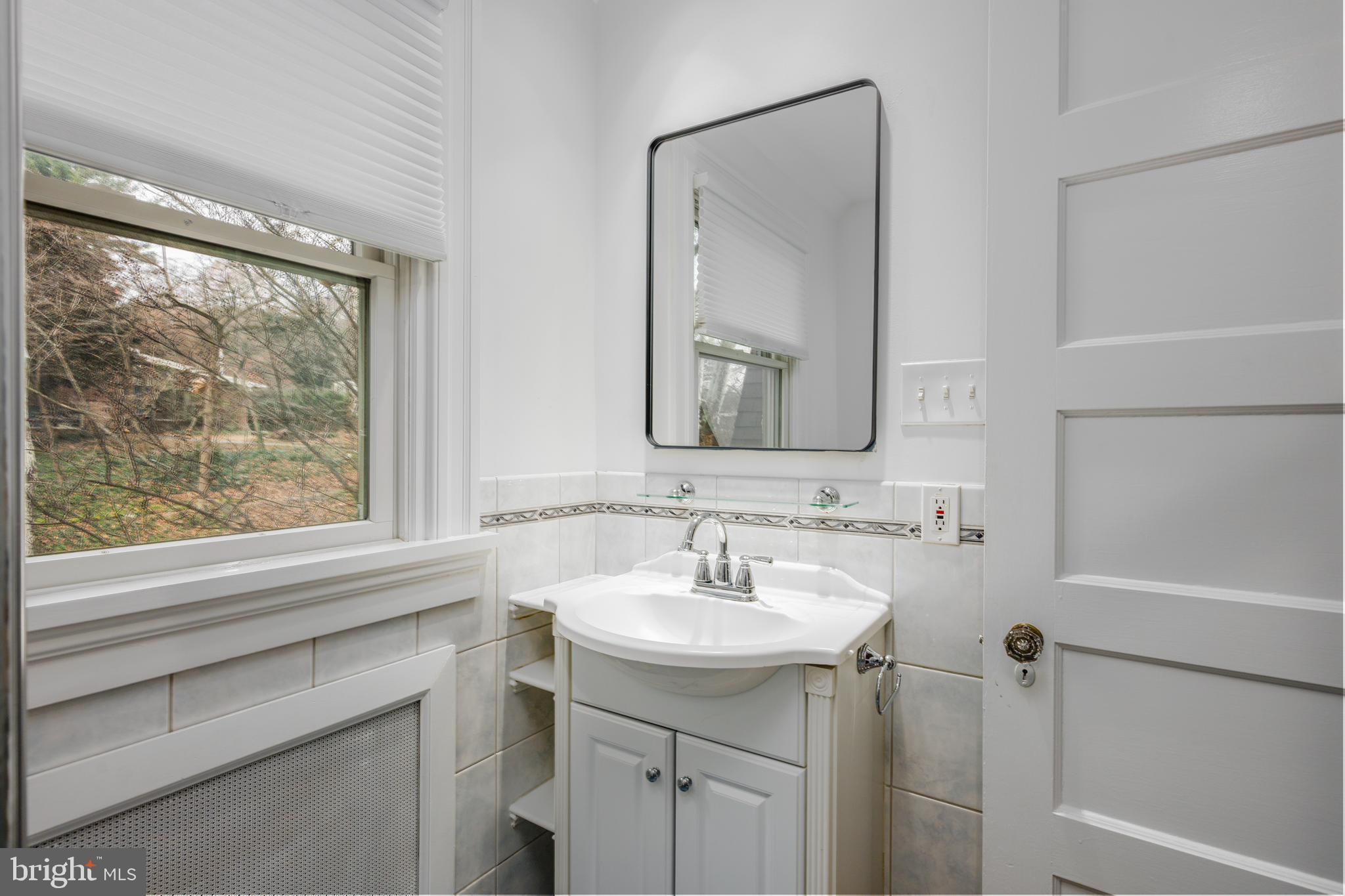 4307 Wickford Road Baltimore, MD 21210 - Photo 20 of 38 a bathroom with a toilet a sink a mirror a and a window