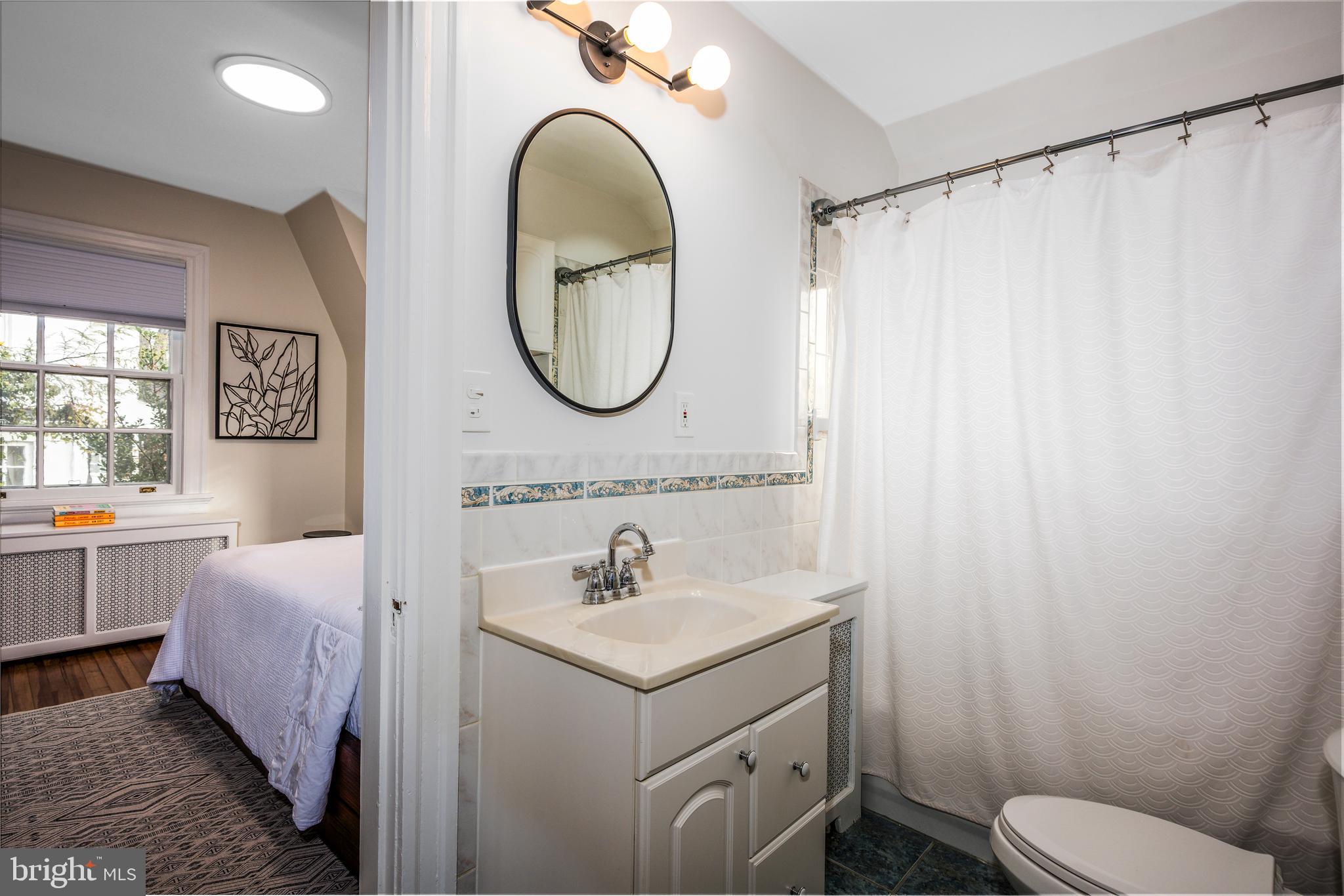 4307 Wickford Road Baltimore, MD 21210 - Photo 24 of 38 a bathroom with a sink a mirror a toilet and a window