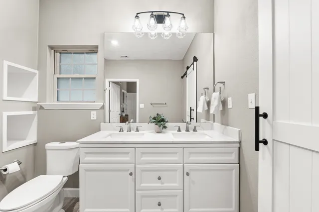 a bathroom with a sink vanity mirror and toilet