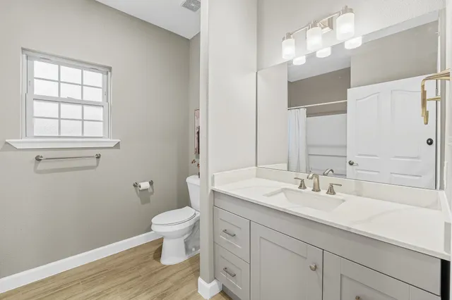 a bathroom with a sink a toilet and a large mirror