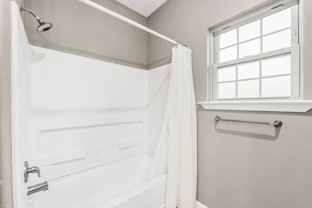 a bathroom with a shower and a window