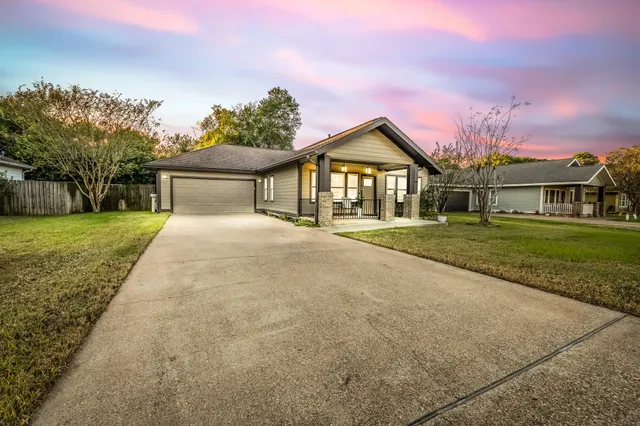 a front view of a house with a yard and trees