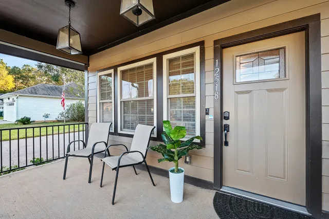a view of a porch with chairs and potted plants
