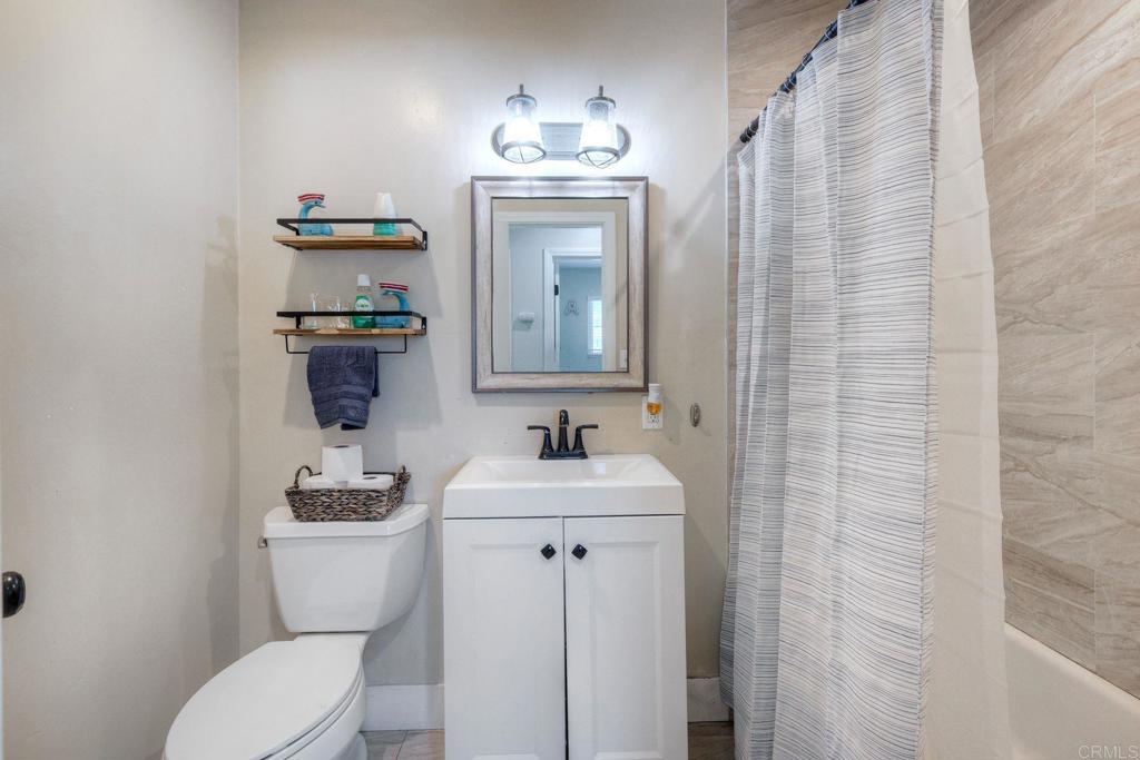 924 Daisy Street Escondido, CA 92027 - Photo 12 of 25 a bathroom with a toilet sink and mirror