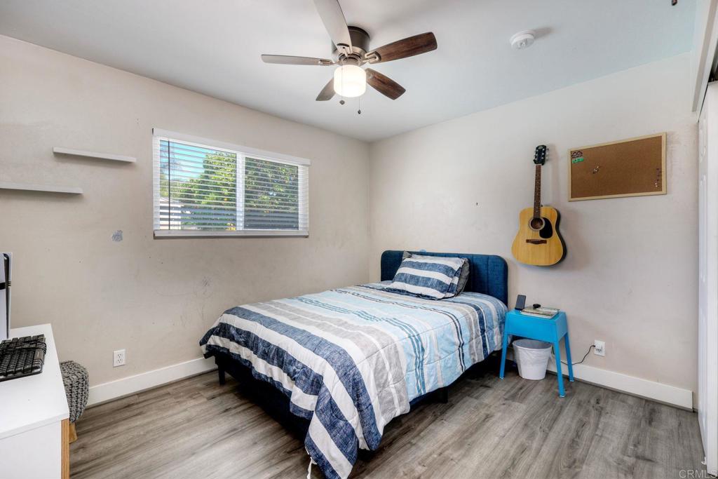 924 Daisy Street Escondido, CA 92027 - Photo 13 of 25 a bedroom with a bed and a chandelier
