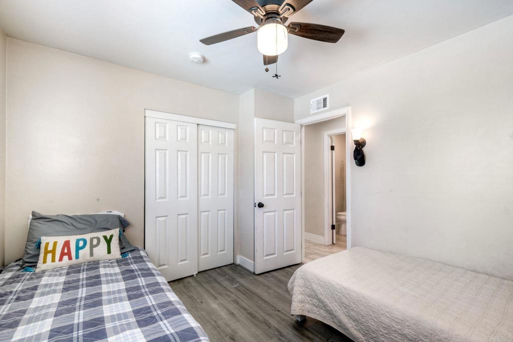 924 Daisy Street Escondido, CA 92027 - Photo 10 of 25 a bedroom with a bed and a chandelier