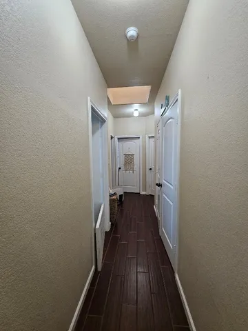 a view of a hallway with wooden floor