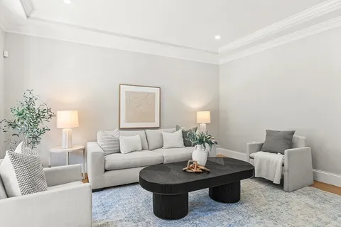 a living room with furniture a lamp and a potted plant