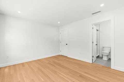 a view of a room with wooden floor and a toilet
