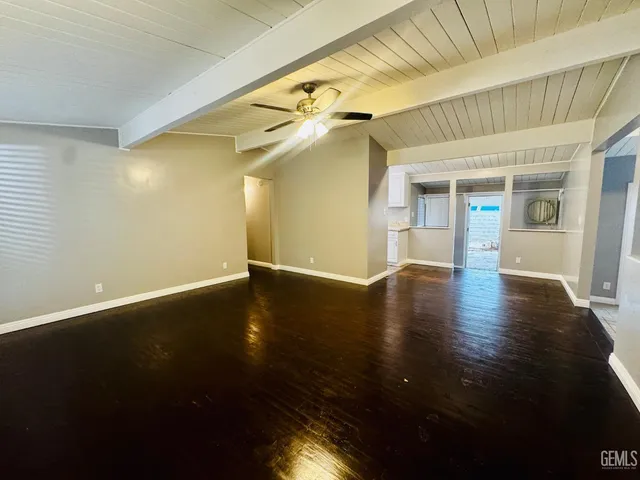 a view of a livingroom with wooden floor and a hallway