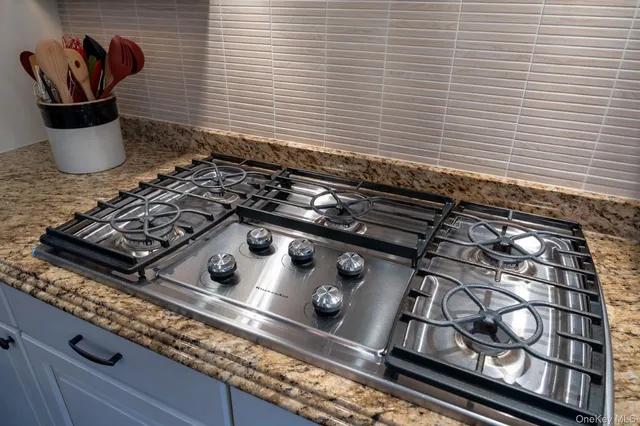a kitchen with stainless steel appliances kitchen island granite countertop a stove and a refrigerator