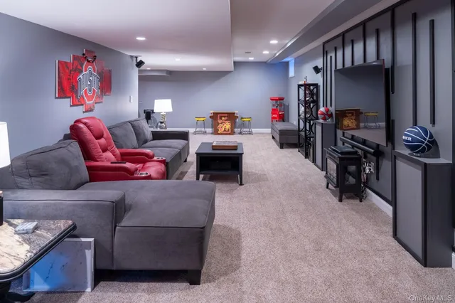 a living room with furniture a flat screen tv and kitchen view