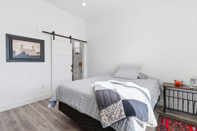 886 North 300th East Spring City, UT 84662 - Photo 21 of 40 Bedroom featuring a barn door and wood finished floors