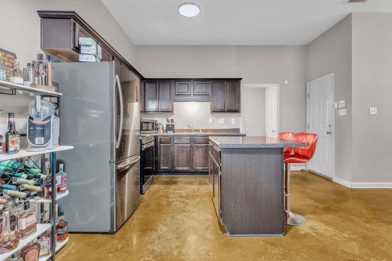 5616 Falling Bark Drive Memphis, TN 38134 - Photo 8 of 15 a kitchen with stainless steel appliances granite countertop a refrigerator a sink dishwasher a stove and a dining table with wooden floor