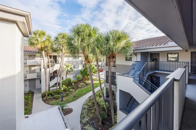 a view of a balcony with chairs potted plants and wooden fence