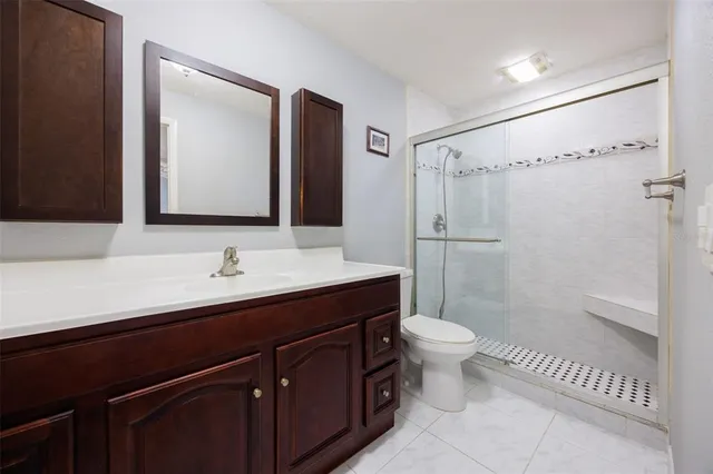 a bathroom with a sink a toilet a shower and a mirror