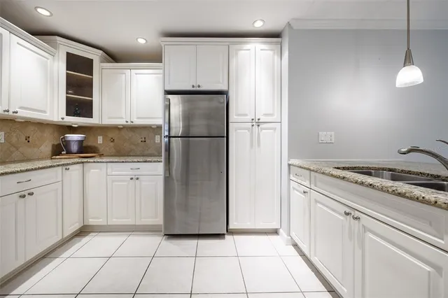 a kitchen with a refrigerator a stove top oven and cabinets