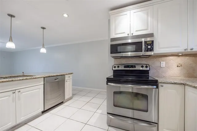 a kitchen with granite countertop white cabinets stainless steel appliances and sink