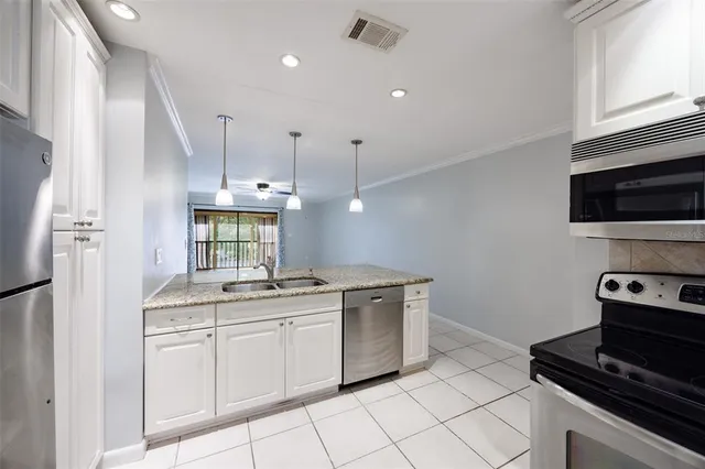 a kitchen with a sink stainless steel appliances and cabinets