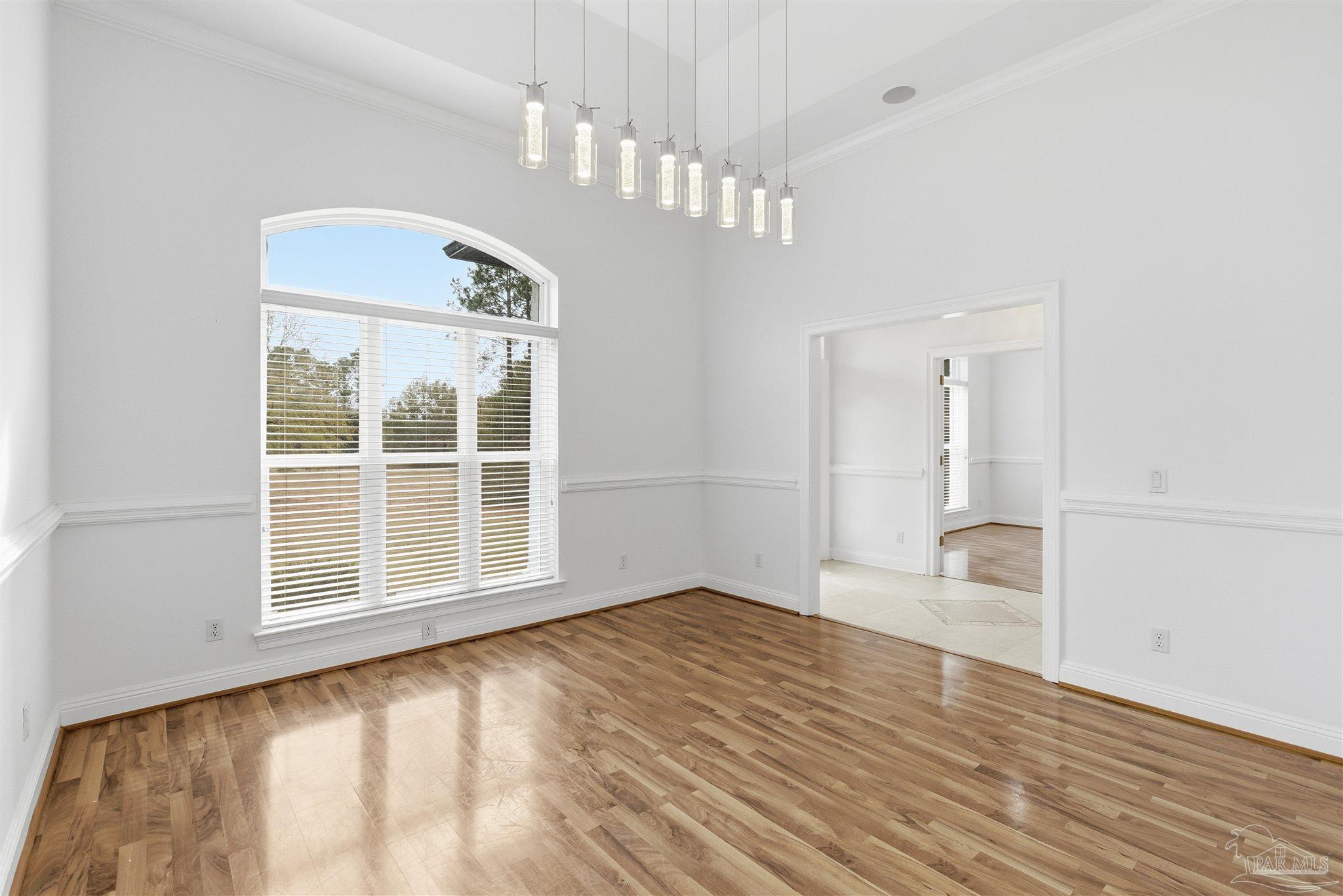 6786 Quintette Road Pace, FL 32571 - Photo 12 of 60 a view of an empty room with wooden floor and a window