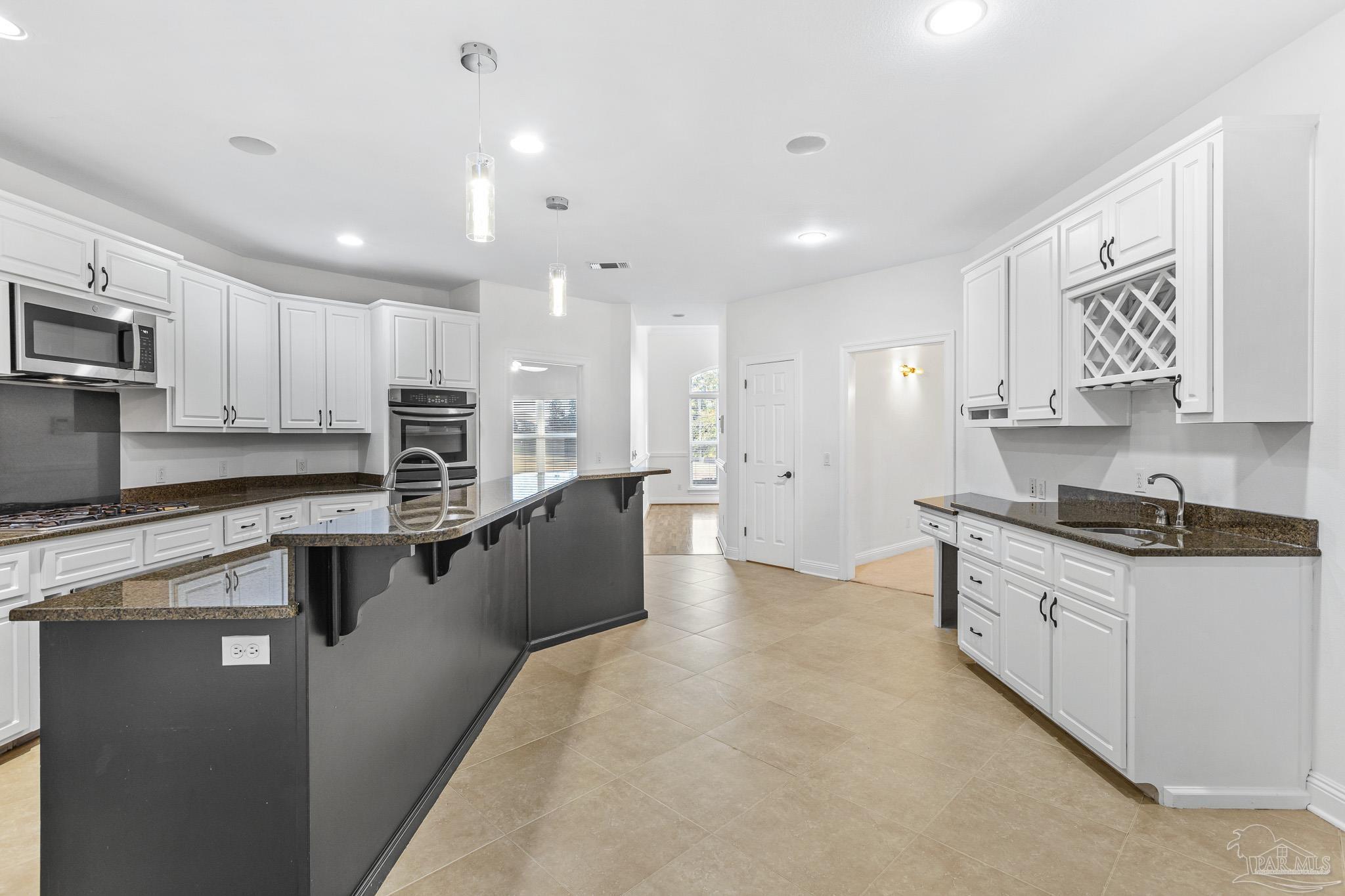 6786 Quintette Road Pace, FL 32571 - Photo 15 of 60 a large kitchen with stainless steel appliances lots of counter space sink and cabinets