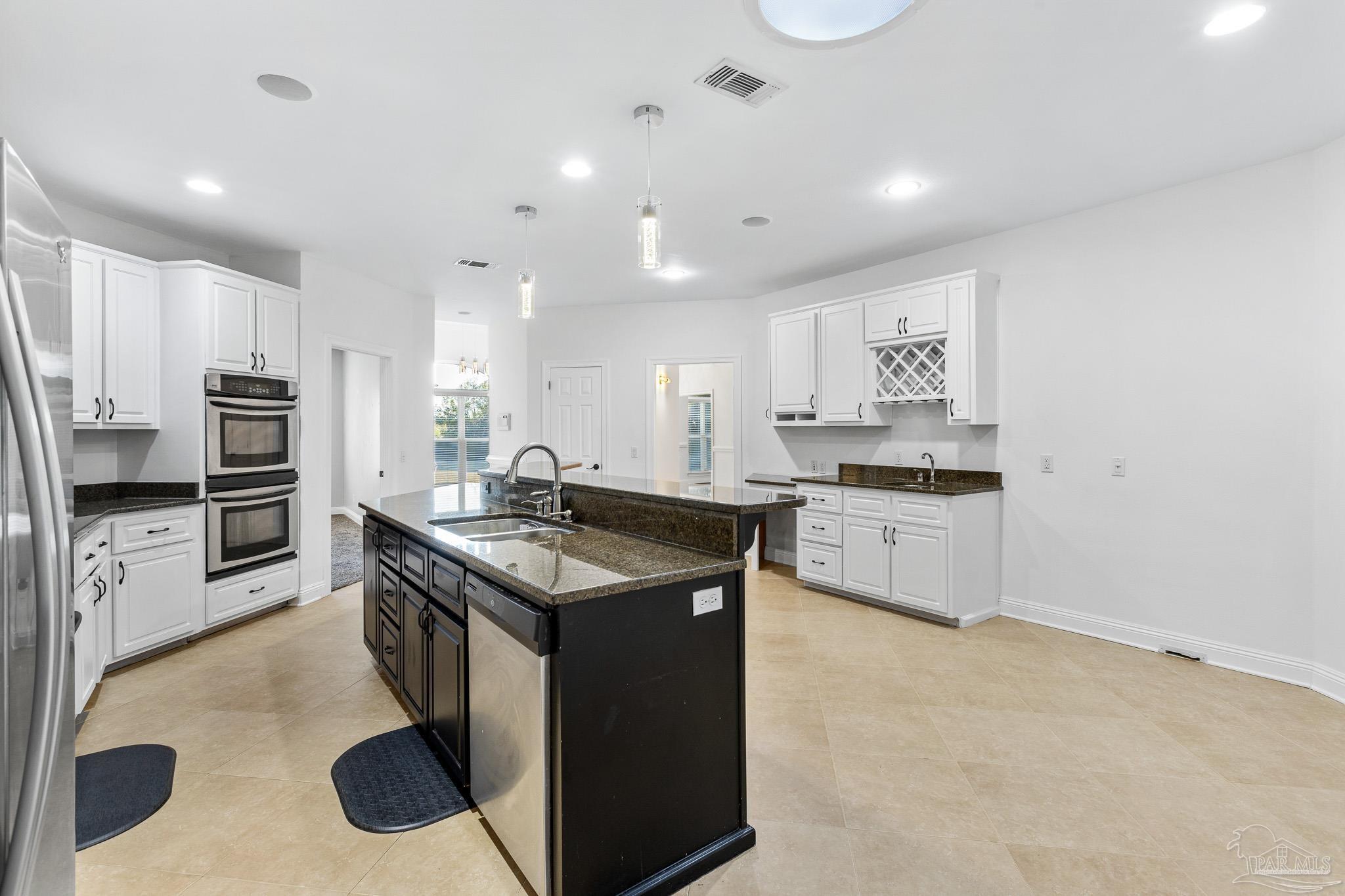 6786 Quintette Road Pace, FL 32571 - Photo 18 of 60 a kitchen with stainless steel appliances granite countertop a stove top oven a sink a refrigerator and white cabinets