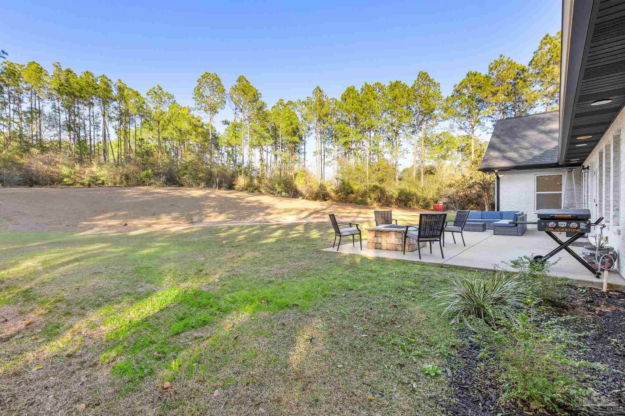 6786 Quintette Road Pace, FL 32571 - Photo 48 of 60 a backyard of a house with table and chairs