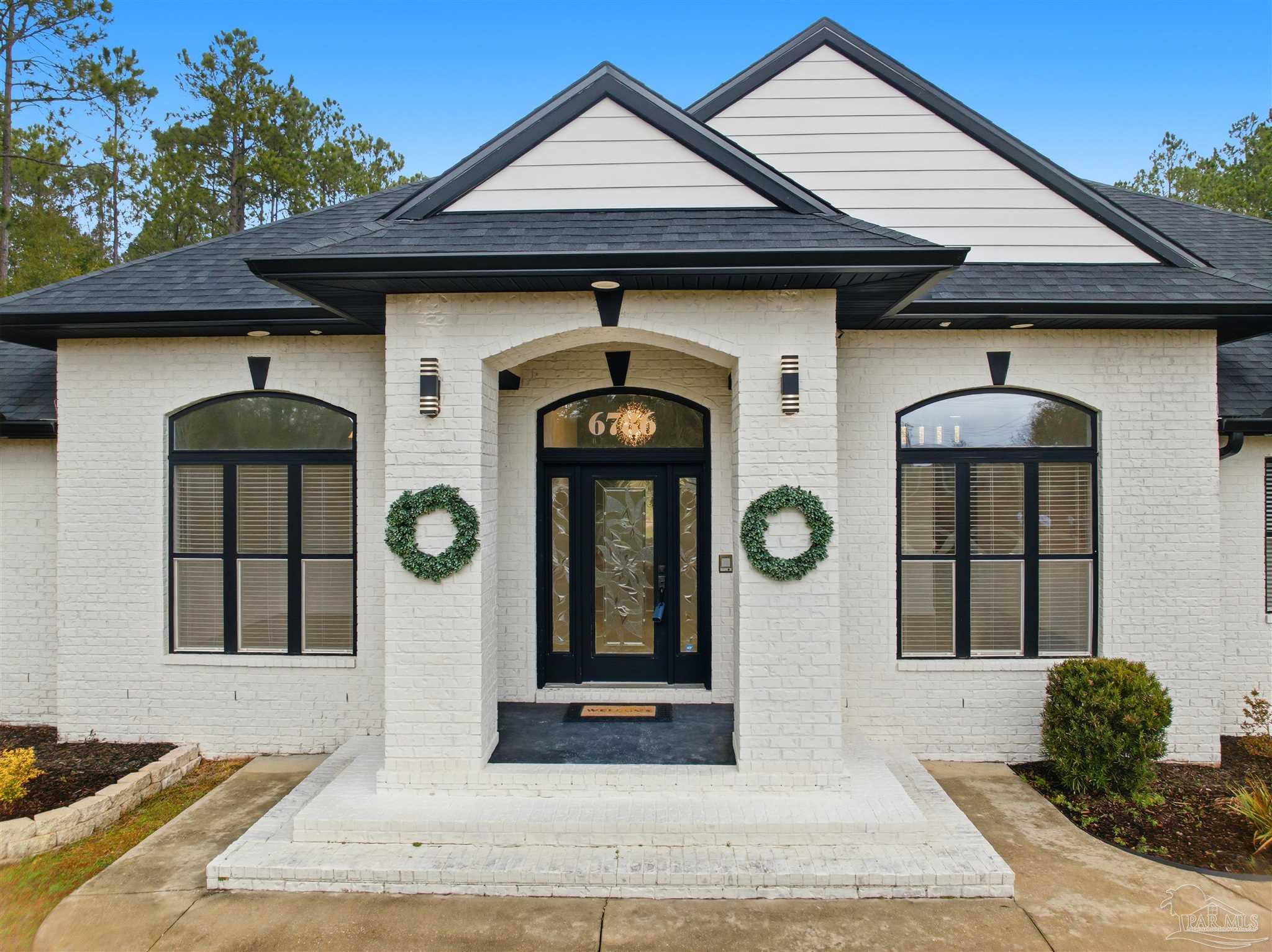 6786 Quintette Road Pace, FL 32571 - Photo 5 of 60 a front view of a house with garden