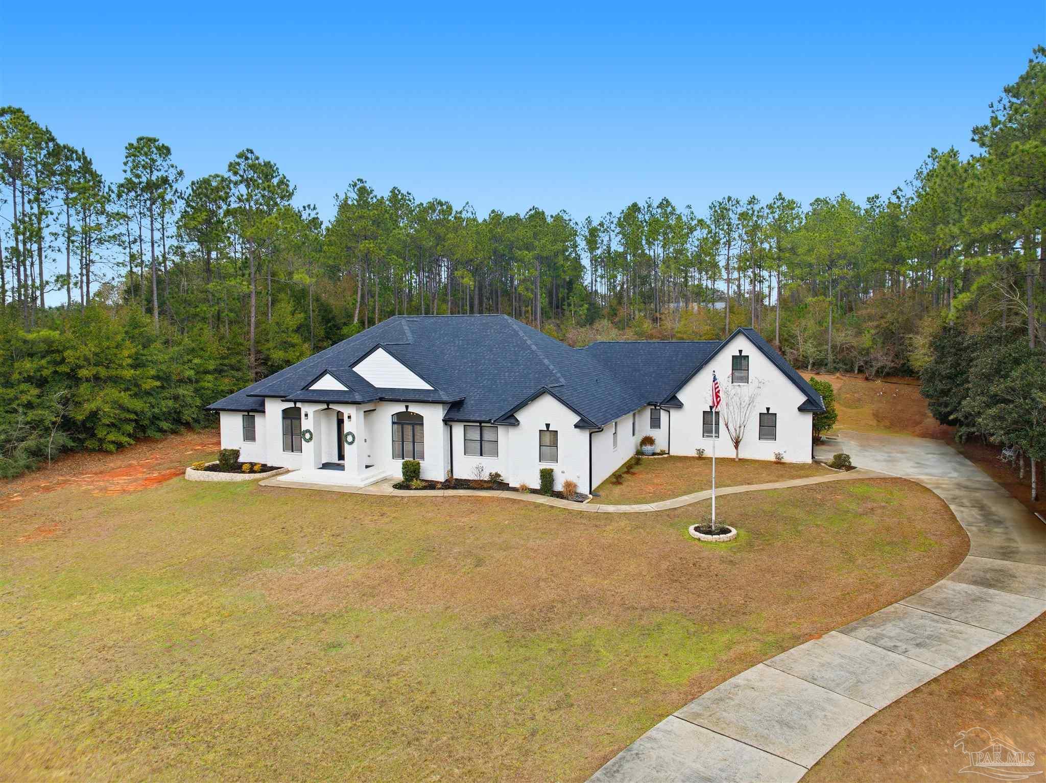 6786 Quintette Road Pace, FL 32571 - Photo 6 of 60 an aerial view of a house with swimming pool and green space