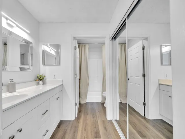 a spacious bathroom with a double vanity sink a mirror and a shower